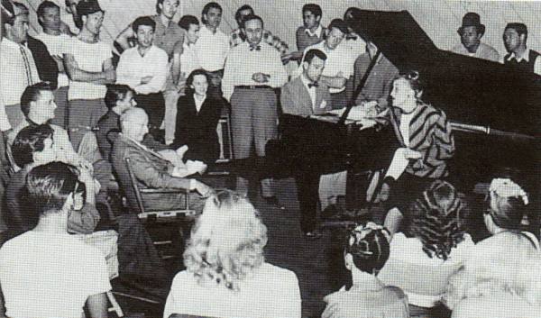 The Freed Unit circa 1945, with Roger Edens on piano, flanked by Arthur Freed (left) and Conrad Salinger, with Kay Thompson singing to a rapt Jerome Kern (seated).